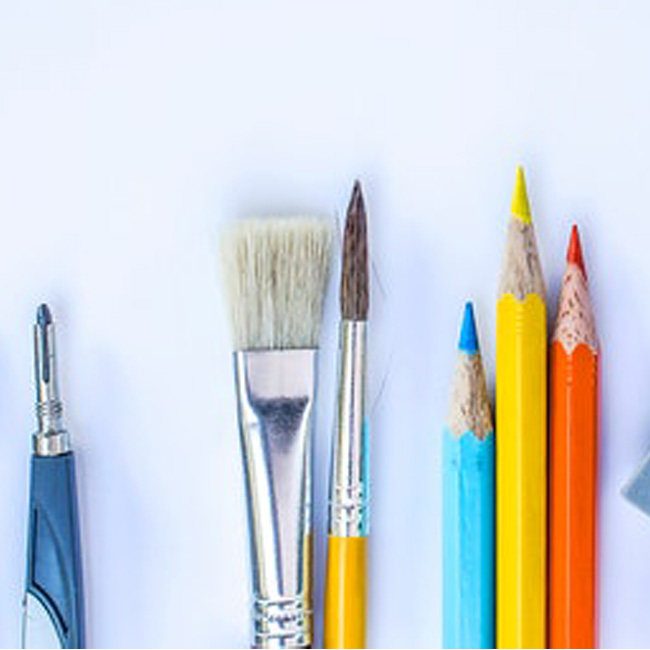 An assortment of pen, colored pencils, and paintbrushes.